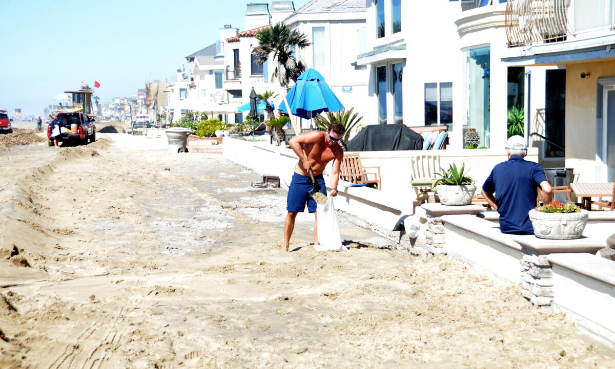 Newport Beach lifeguards and city crews fill sandbags