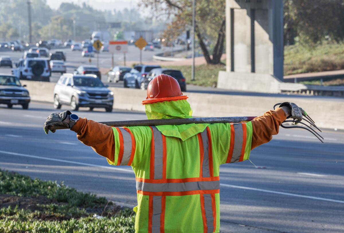 Gabriel Gonzalez of the Chrysalis Roads program walks with a tool over his shoulders