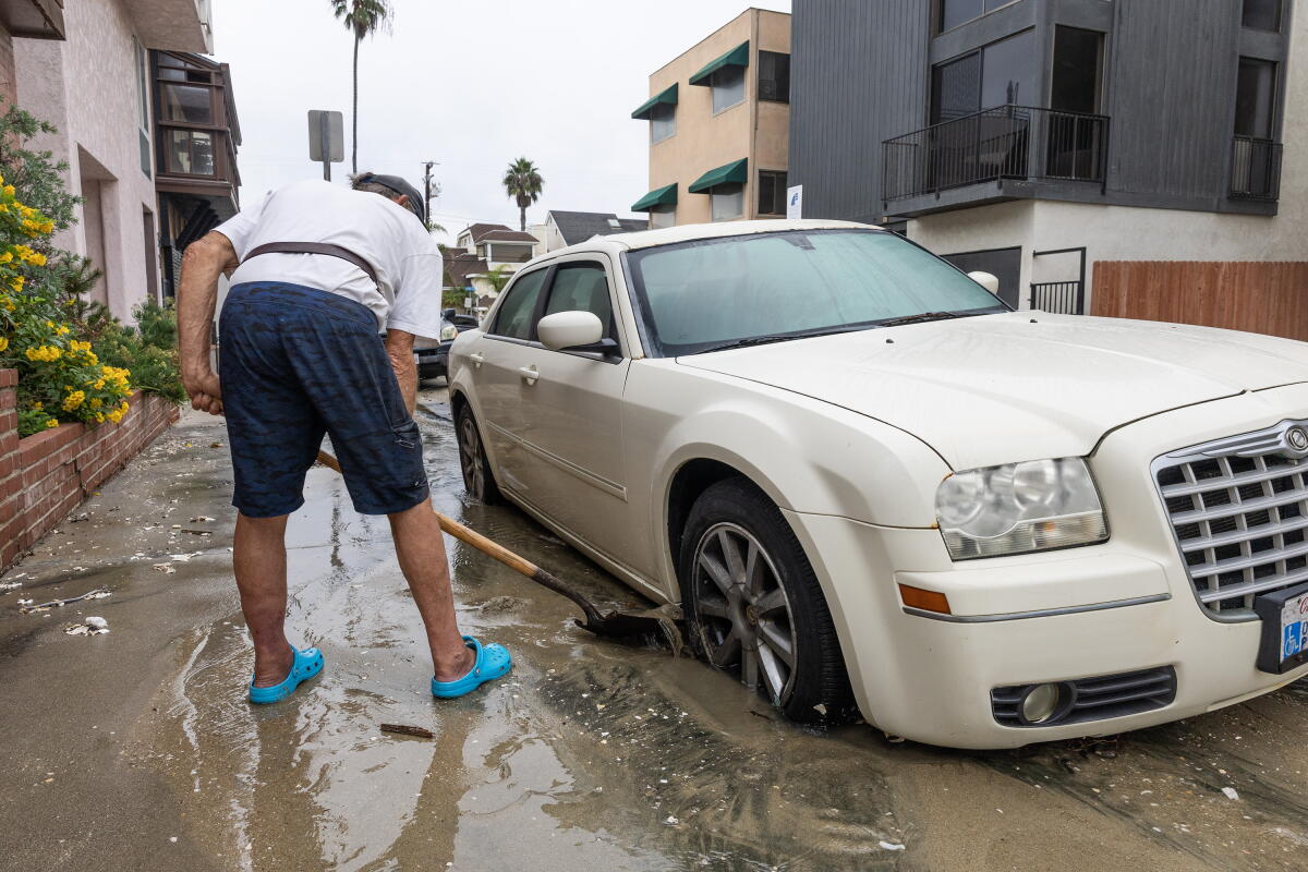 Robert Wells digs sand away from his car tires at 69th Place on the Long Beach Peninsula on Saturday.
