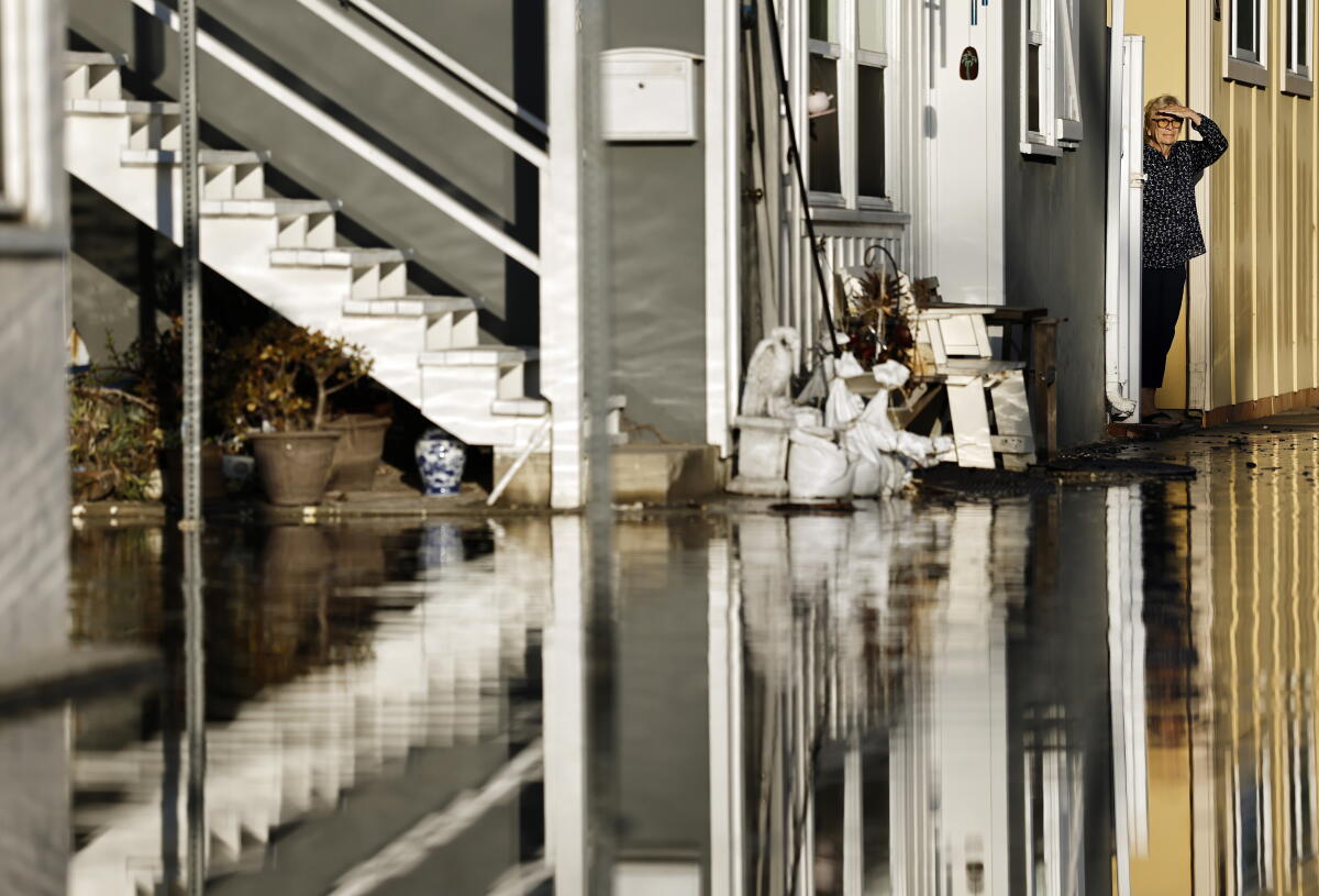 A person standing near a flooded street
