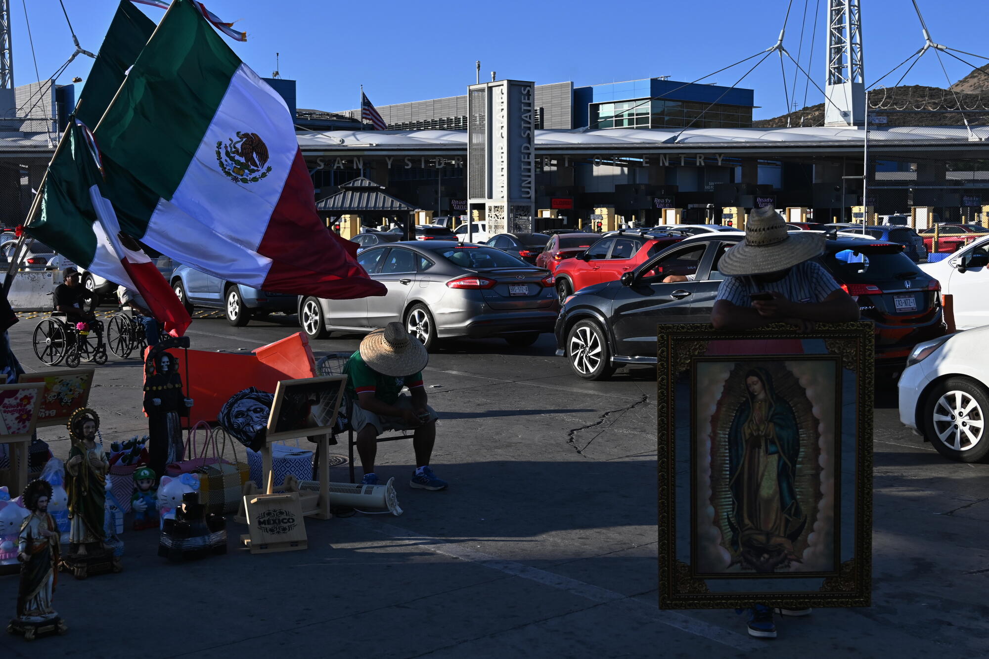 Merchants sell religious icons and Mexican flags to ongoing vehicles crossing into San Diego, Calif. from Tijuana, Mexico