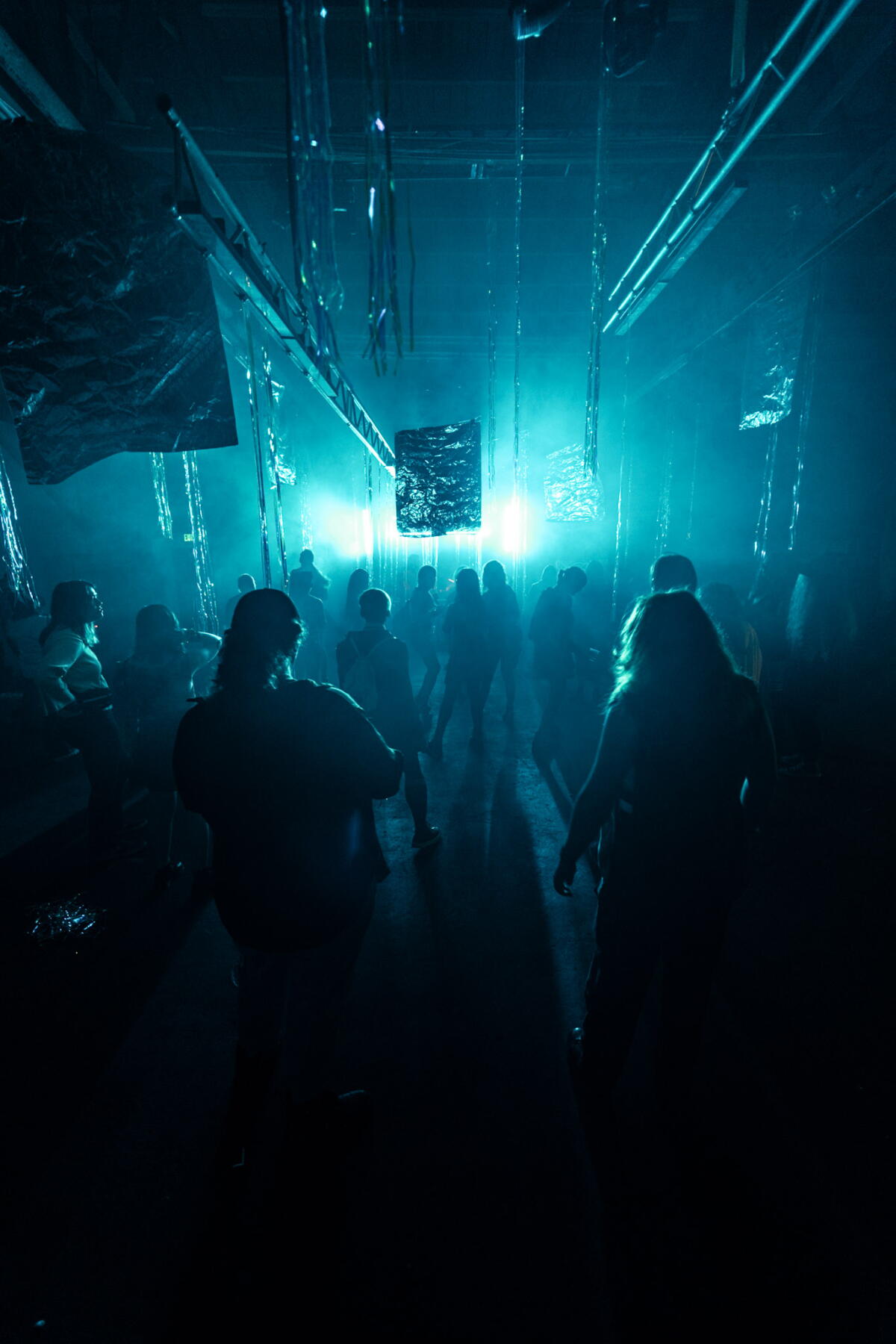 Ravers dancing in the dark in a warehouse