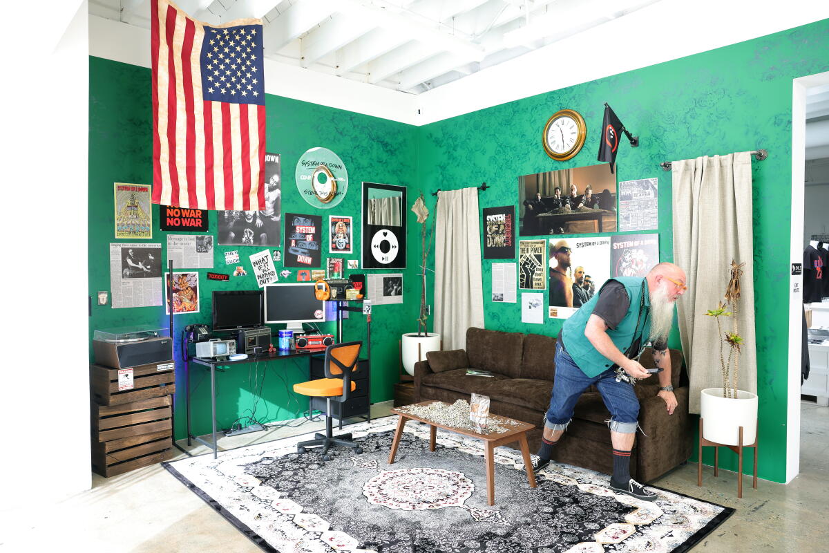 Designer Bryan Ray Turcotte sits in an anniversary exhibit for L.A. band System of a Down 