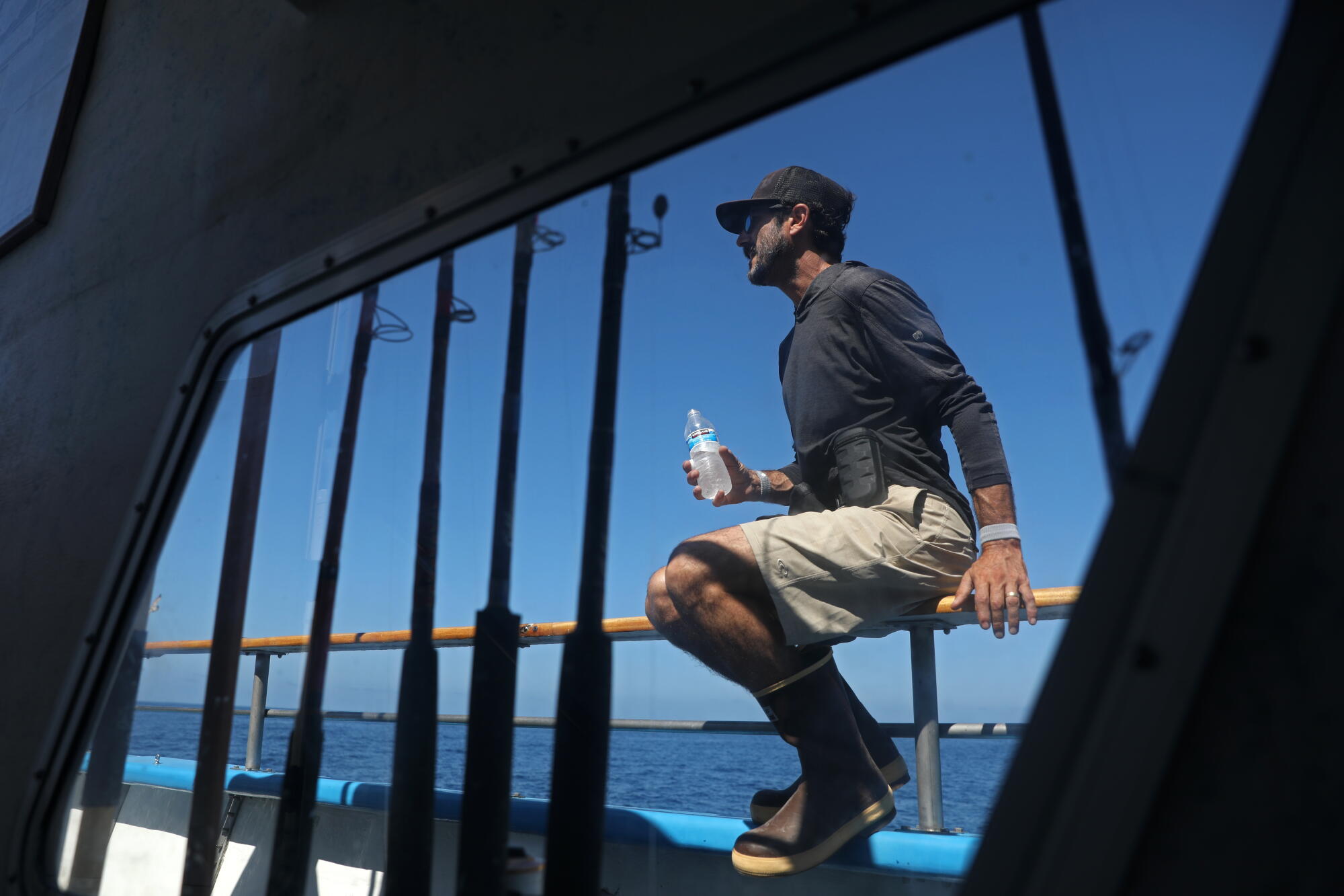 David Koligian, of Ladera Ranch, is framed by fishing rods aboard the Dana Pride.