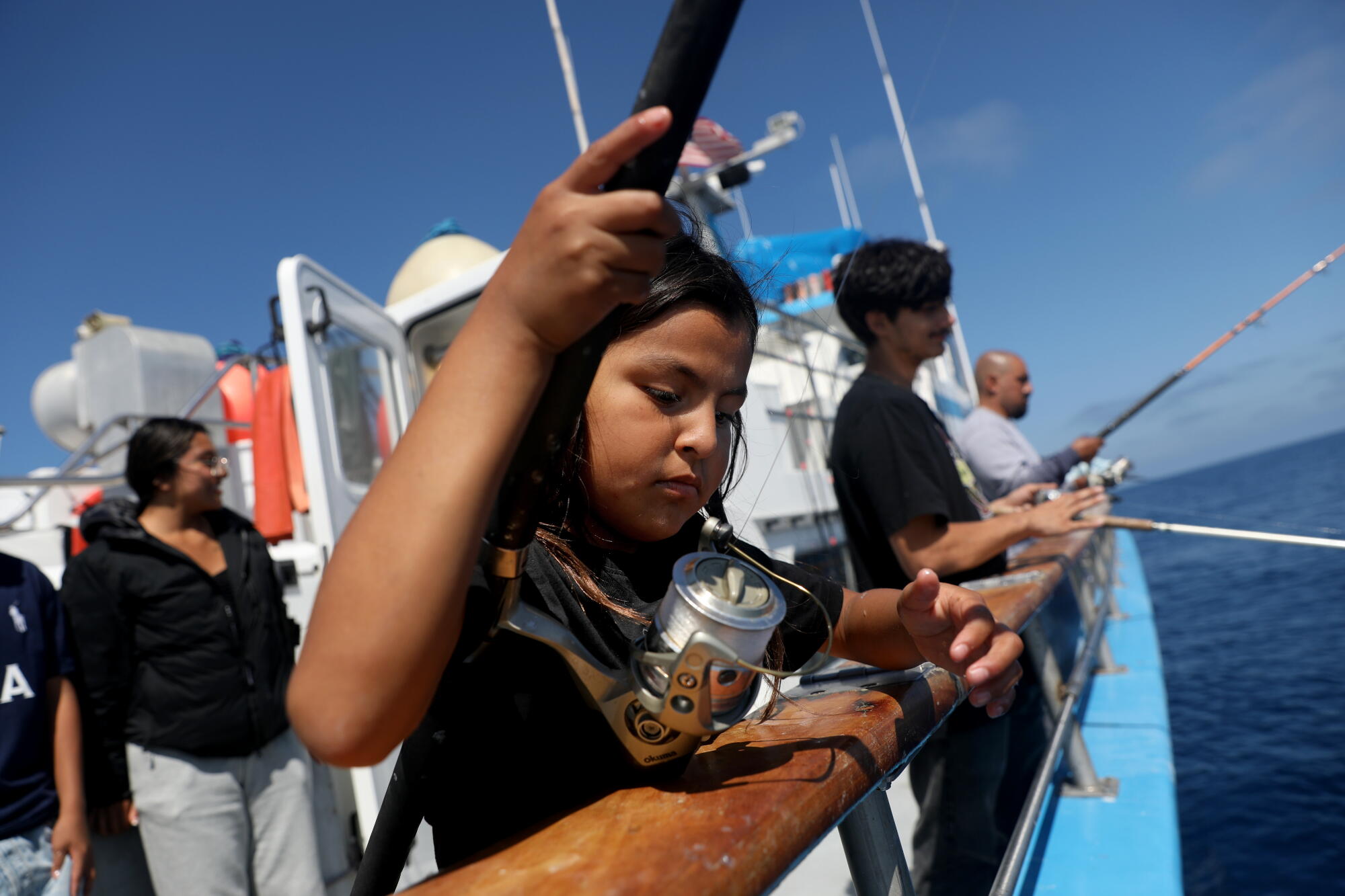 Olivia Solis, 9, cast her line while fishing aboard the Dana Pride.