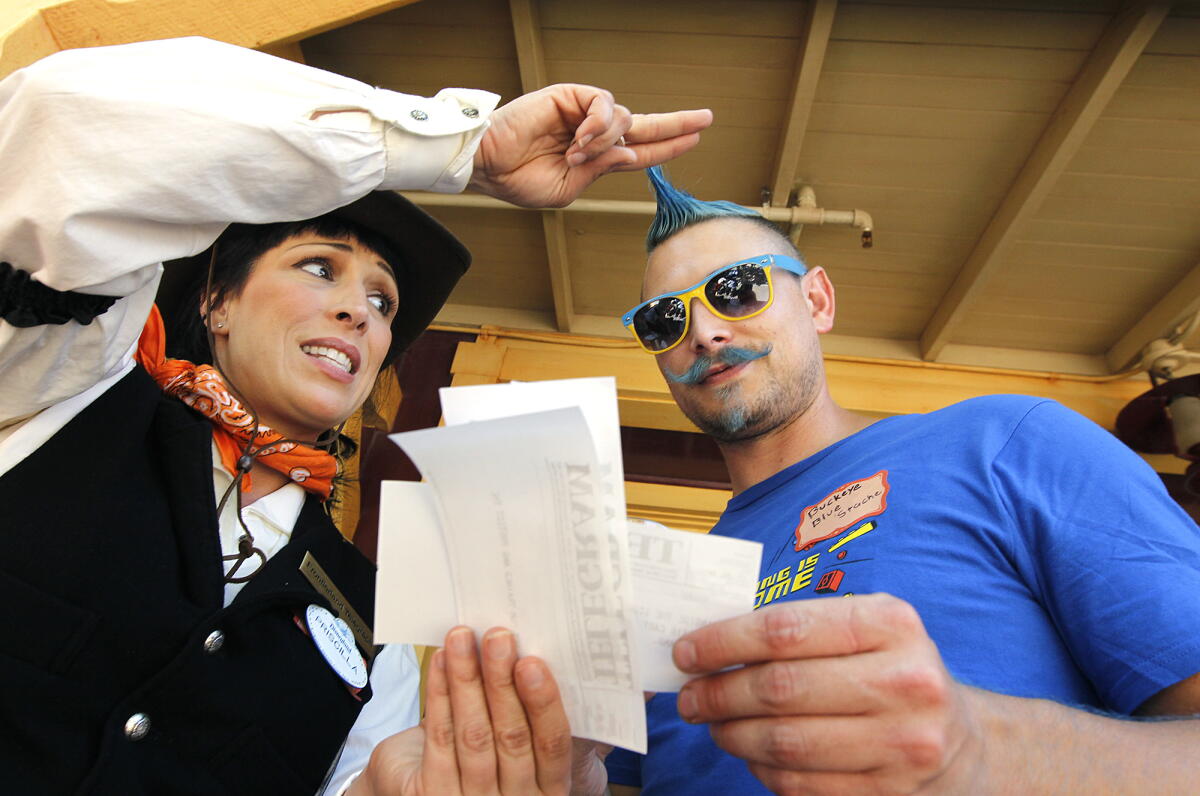 Jennifer Bascom, left, of Disneyland, gives a telegram to Disneyland guest Keith Kocienski of Fullerton.
