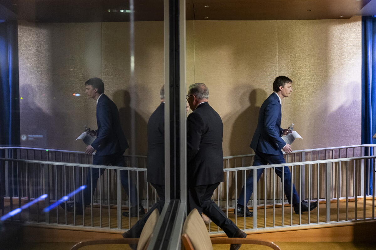 Two men in dark suits walking away from each other 