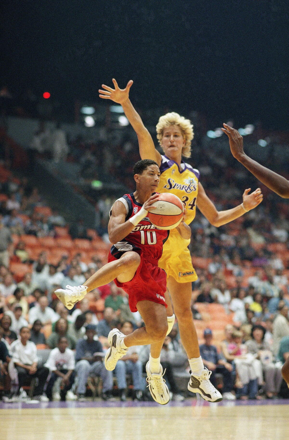 Heidi Burge, right, rises up to block Houston Comets guard Kim Perrot during a game on July 16, 1997.