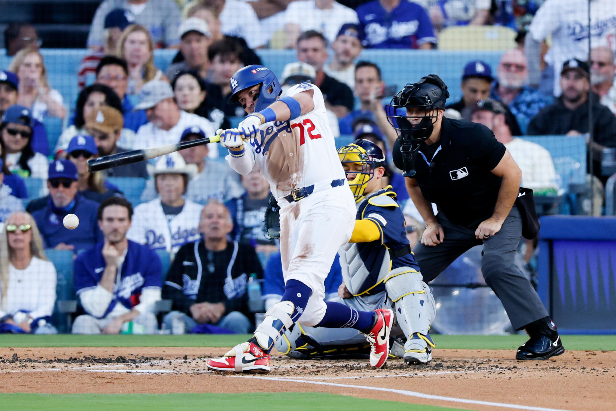 Miguel Rojas hits a single during Game 3 of the NLCS against the Brewers on Wednesday.