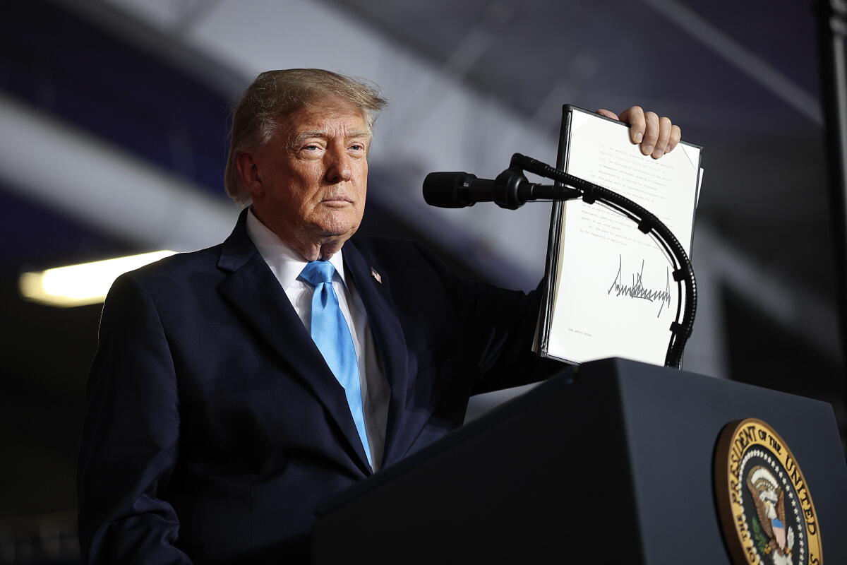 President Trump signs an executive order to lower the cost of diesel fuel during a campaign rally