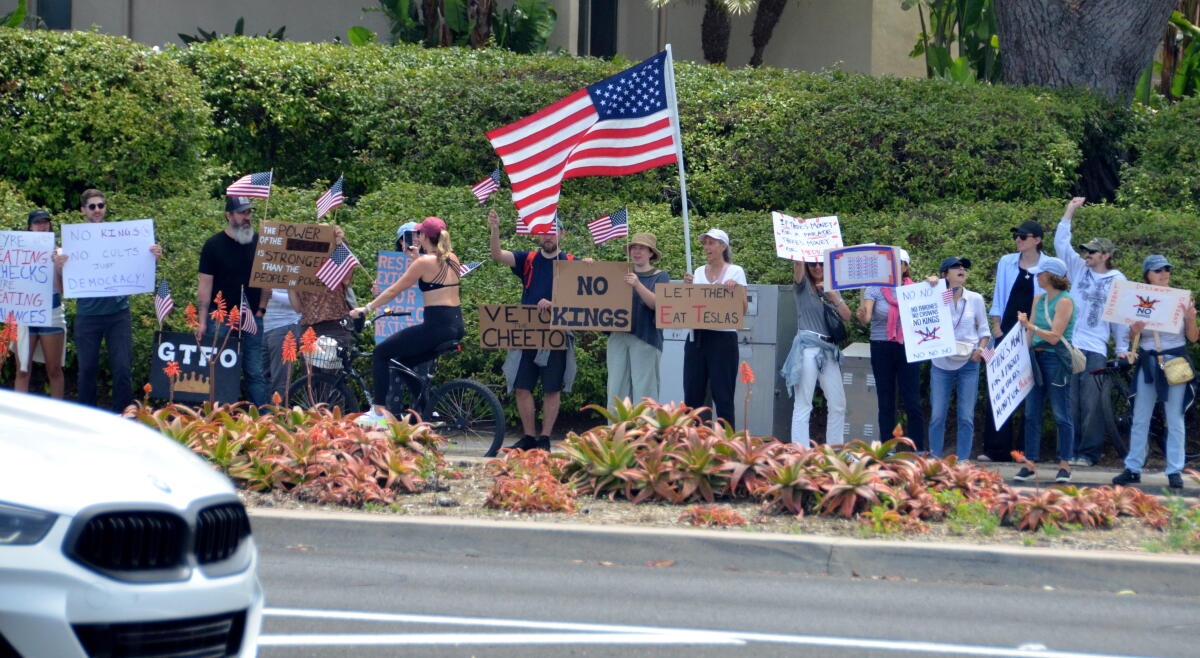 Hundreds line Coast Highway at Jamboree Road to take part in the June 14, 2025, "No Kings" protest.