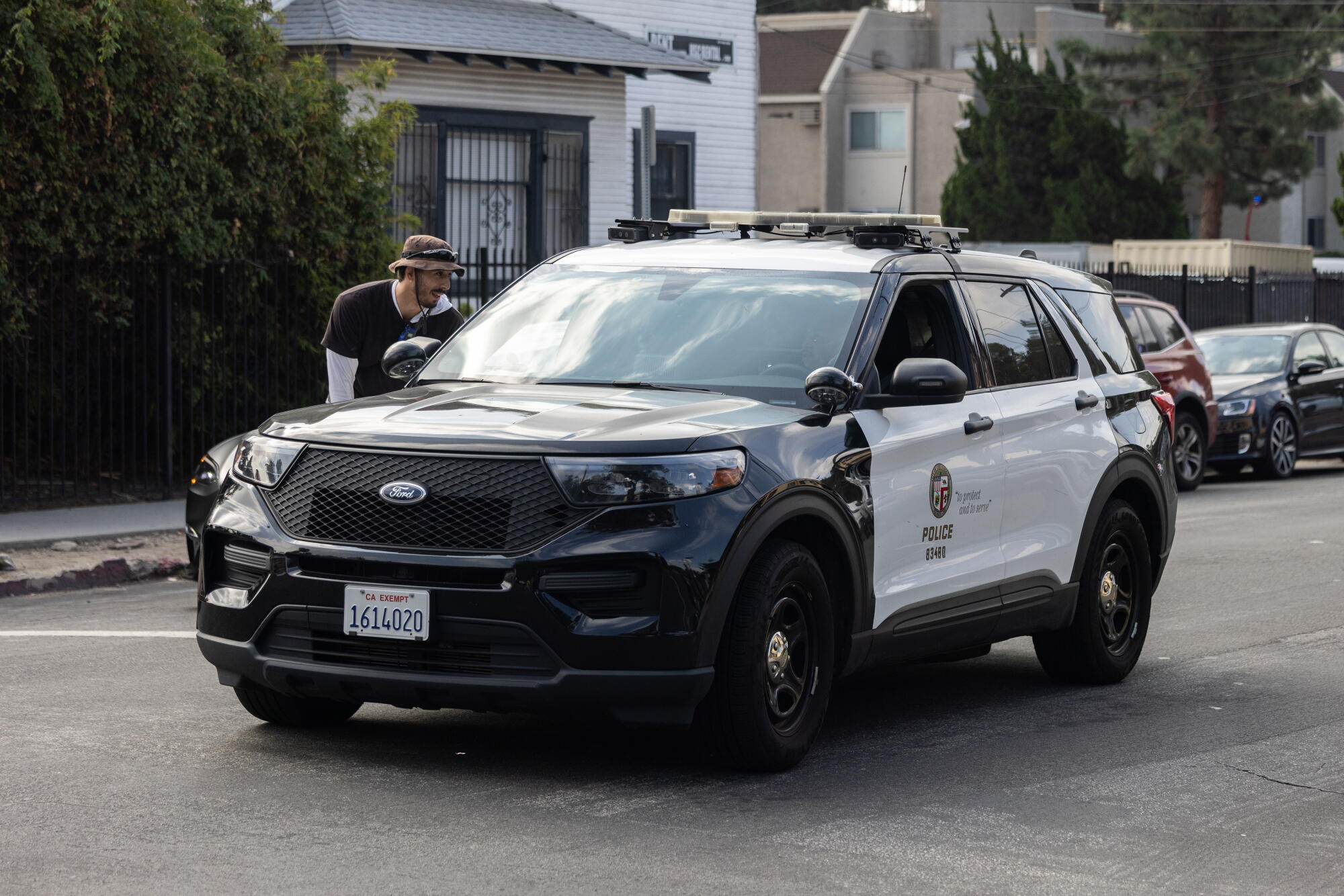 Jonathan Hale interacts with police officers in a patrol vehicle