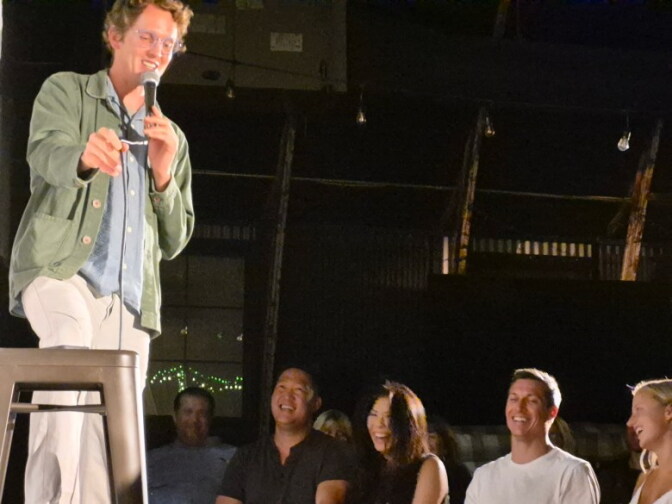 A comedian on stage in front of a crowd.