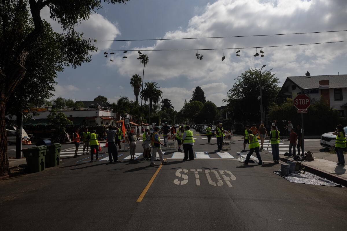 Volunteers led by guerrilla activist Jonathan Hale paint the four crosswalks.