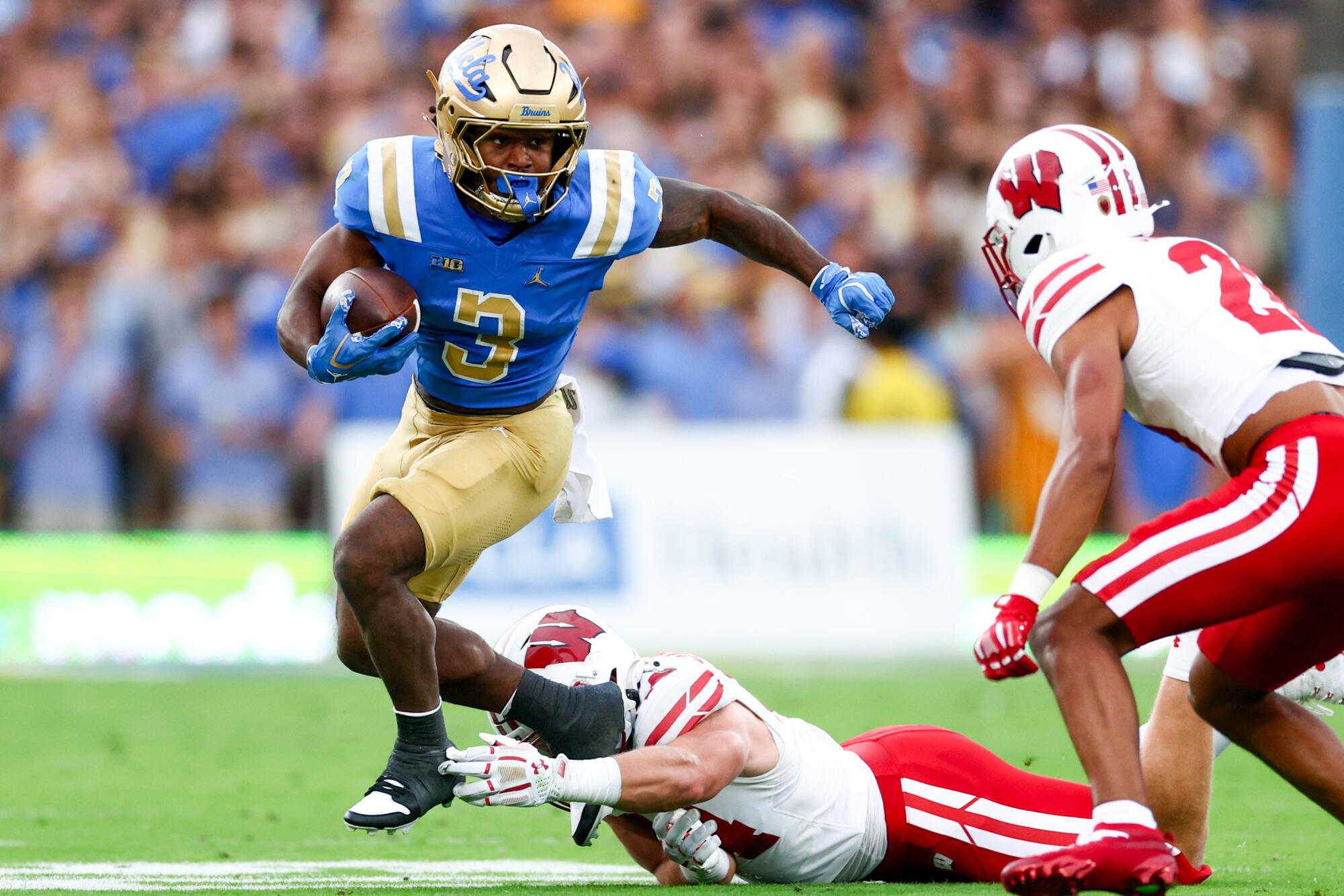 UCLA running back Wayne Knight breaks a tackle from Wisconsin safety Marvin Burks Jr. during the second quarter Saturday.