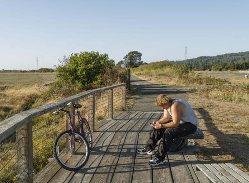 Joshua Soracco, a Cal Poly Humboldt student, takes a break while riding his bike