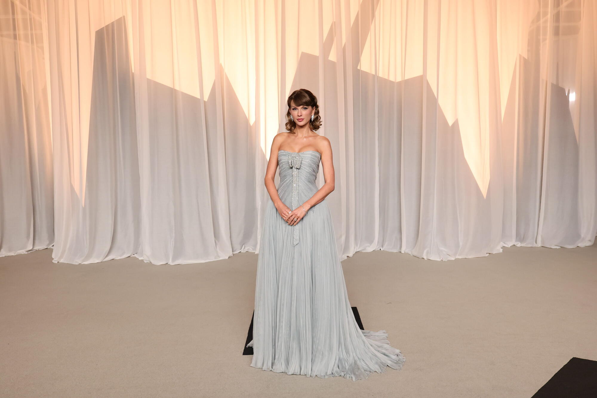 Taylor Swift poses in a flowing baby blue dress. 