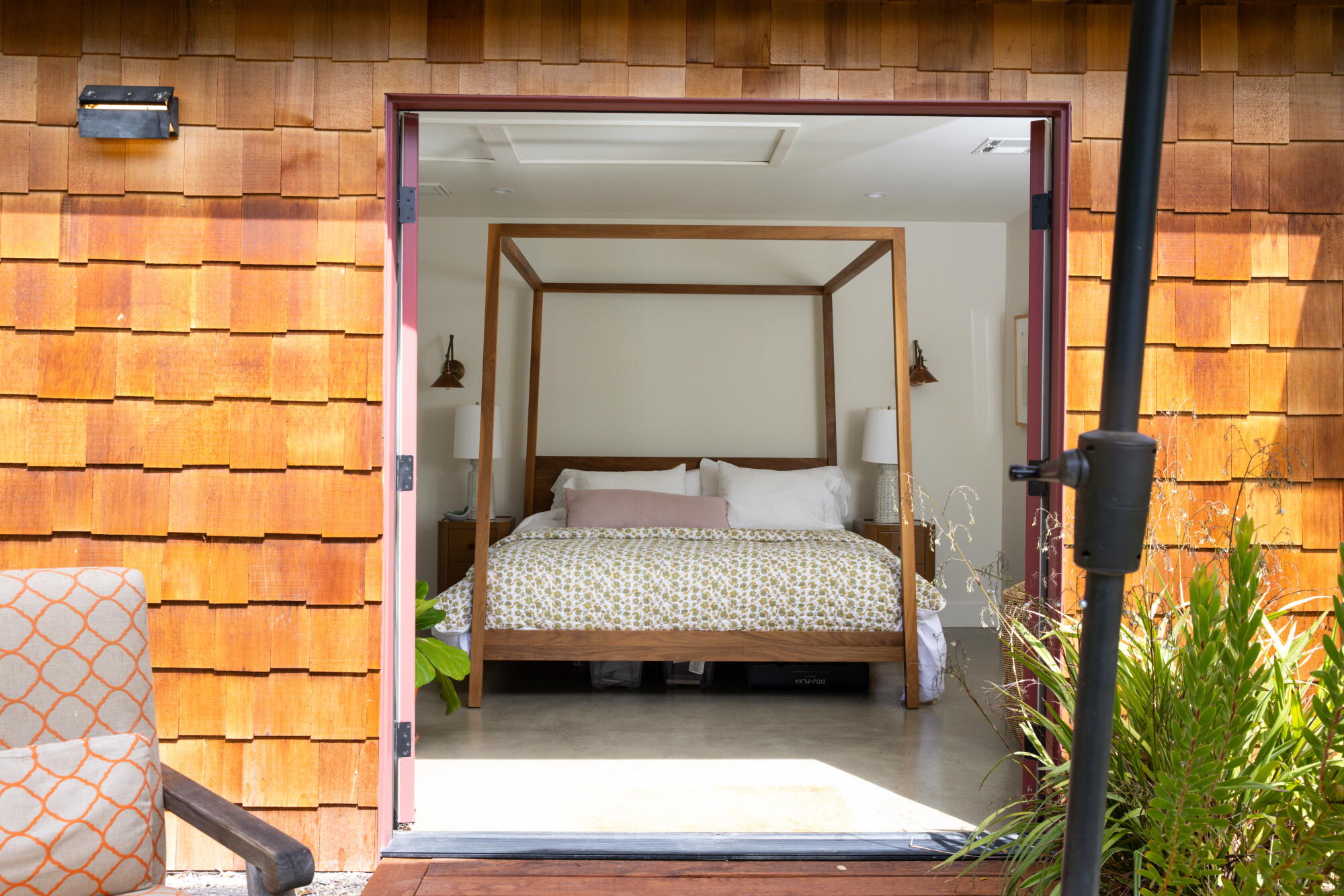 A four-poster bed in a bedroom, seen from the outside of an ADU.