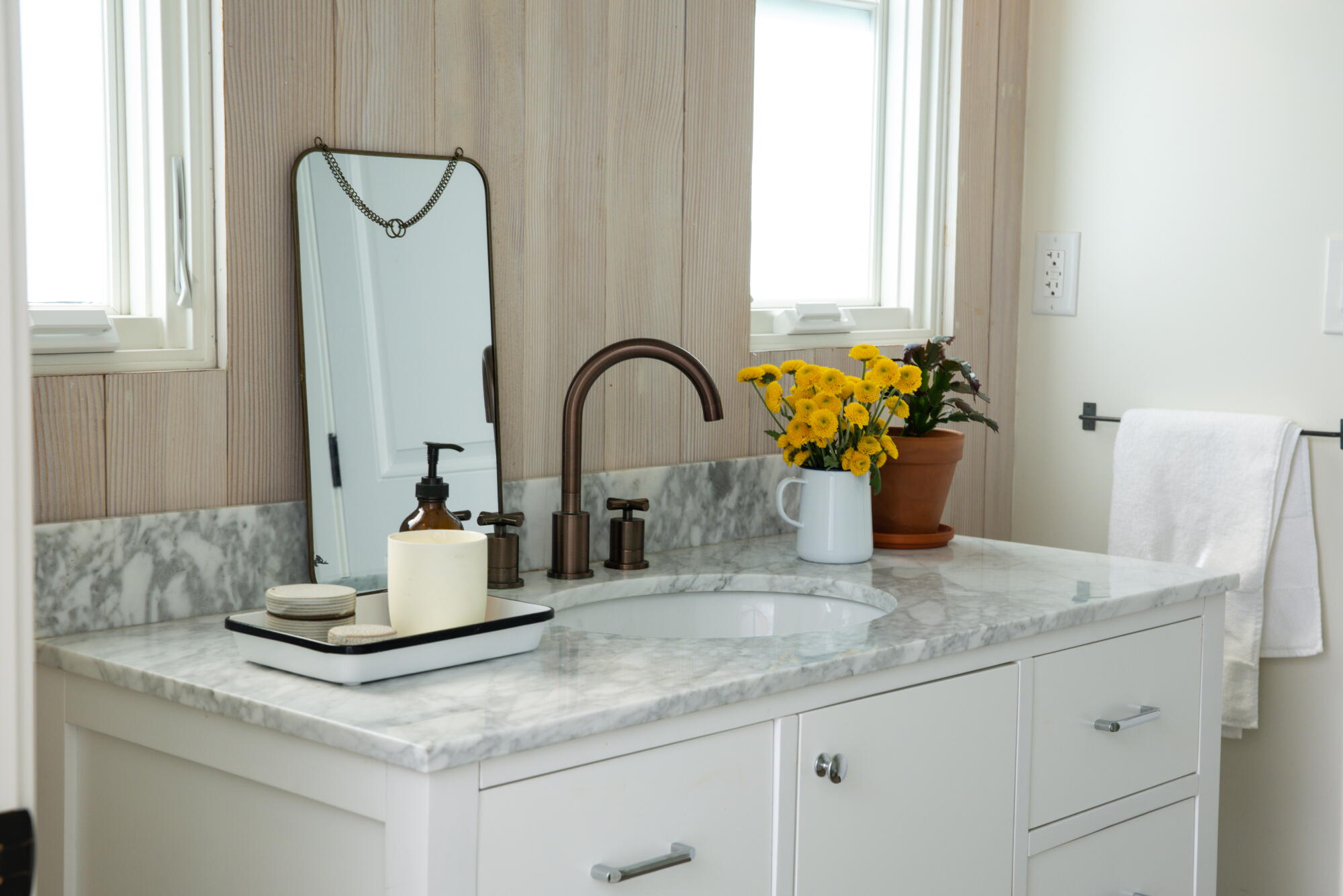 A white vanity with a marble top in a bathroom. 
