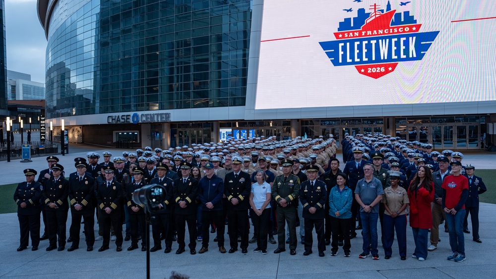 U.S. Sailors, Marines and Coast Guardsmen pose with Fleet Week organizers for a photo during San Francisco Fleet Week