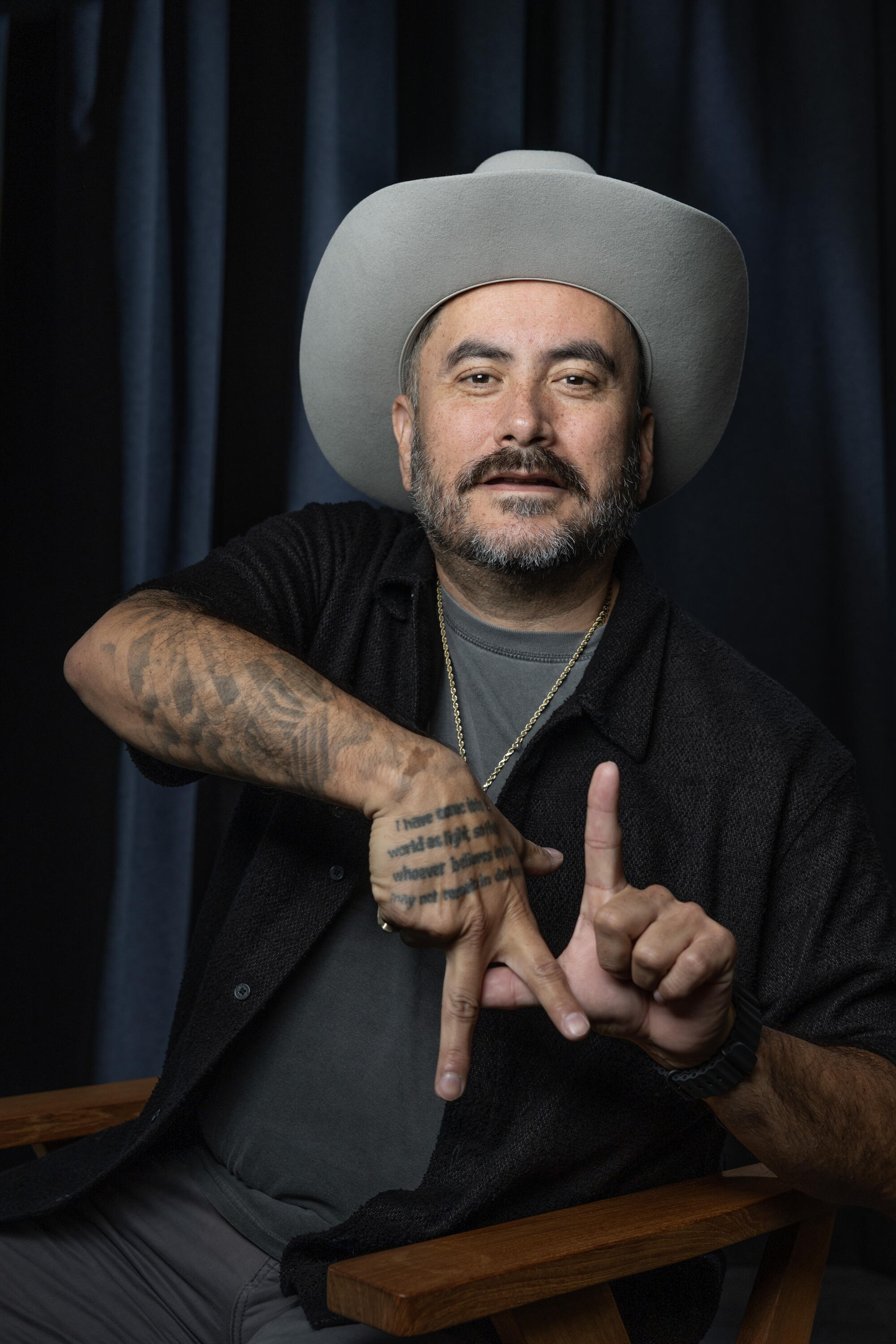Alfred Robles making "LA" sign with tattooed hands