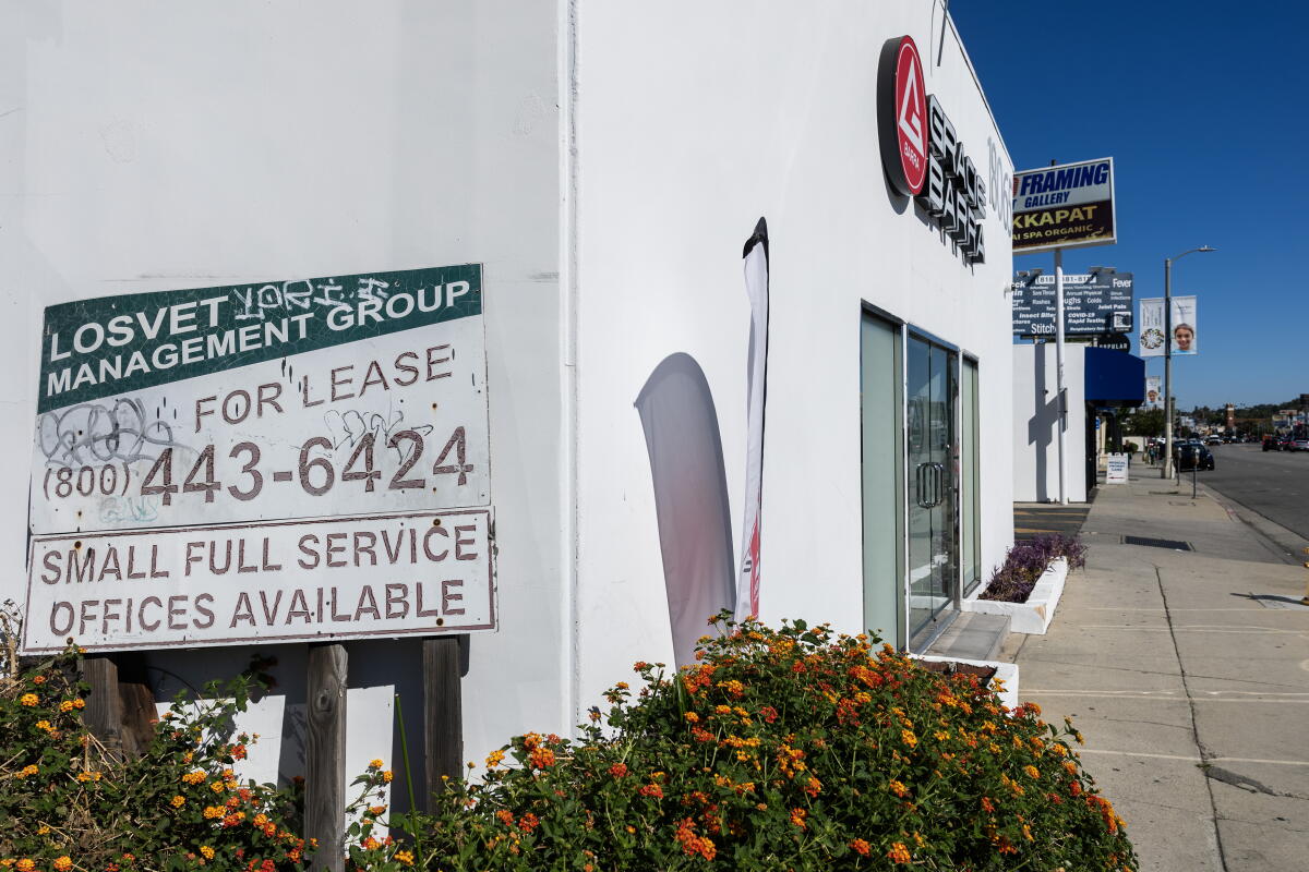 A "For lease" sign on the side of a building.