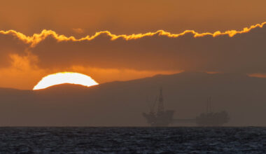 Sun sets near offshore oil rig in California