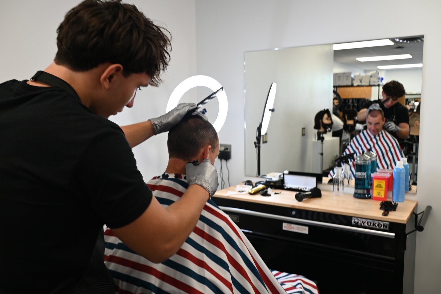 Some students at Long Beach High School are trading pens and pencils for shears and buzzers in Room 208, in the school&rsquo;s new barbering program. Senior Nuri Ipce, left, put his skills to work on Principal Andy Smith.