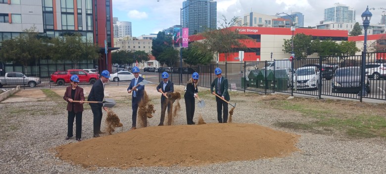 row of people drop dirt