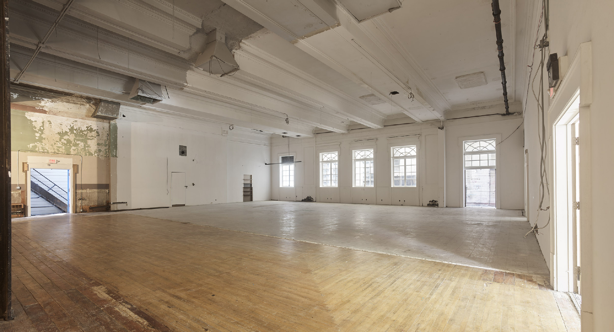 wide empty interior space with wood floors