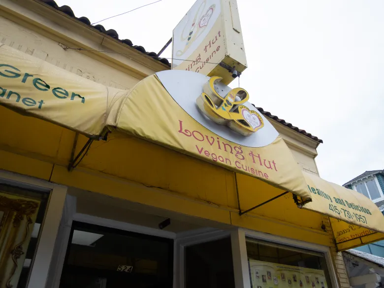Yellow awning above the entrance of Loving Hut Vegan Cuisine, featuring the restaurant’s logo and signage.