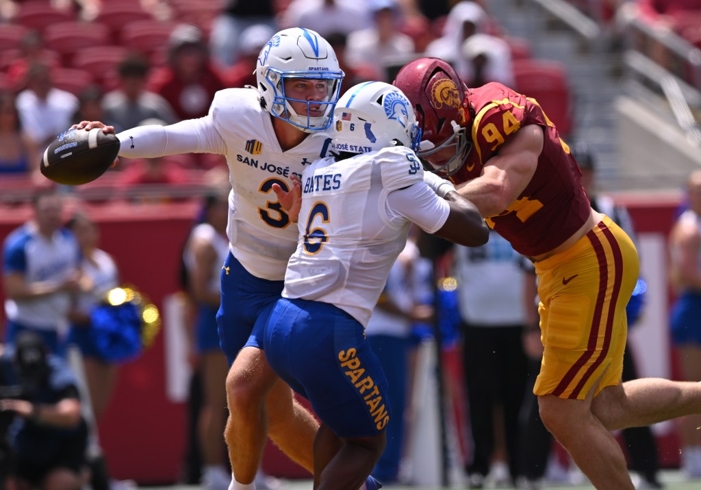 San Jose State quarterback Luke Weaver scrambles with the ball as running back Jabari Bates blocks a USC Trojans defender.