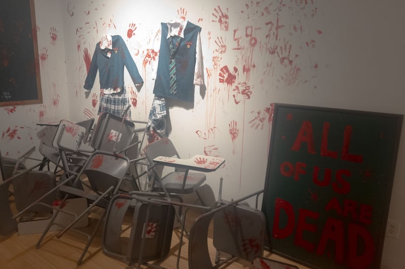 Bloodied uniforms and makeshift barricades are put on display, referencing the Netflix adaptation.