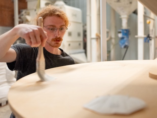 Sam Silberstein uses a paint brush to clean off debris from a Stone Mill used to make flour, during the last day of operation of Admiral Maltings in Alameda, Calif. on October 2nd, 2026. (Douglas Despres for Bay Area News Group)
