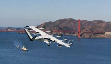 Archer’s white Midnight air taxi, registration N703AX, in forward flight over San Francisco Bay with the Golden Gate Bridge behind