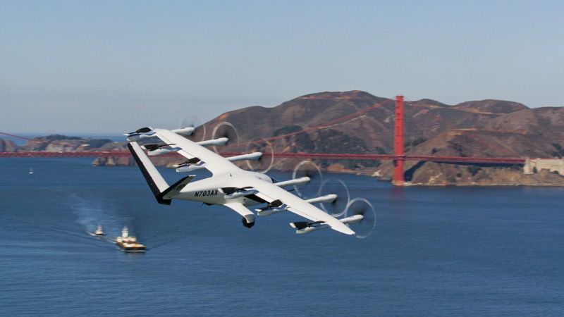 Archer’s white Midnight air taxi, registration N703AX, in forward flight over San Francisco Bay with the Golden Gate Bridge behind