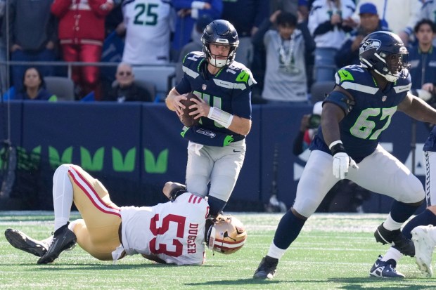 San Francisco 49ers linebacker Jaden Dugger (53) sacks Seattle Seahawks quarterback Sam Darnold (14) during the first half of an NFL football game Sunday, Oct. 11, 2026, in Seattle. (AP Photo/Stephen Brashear)