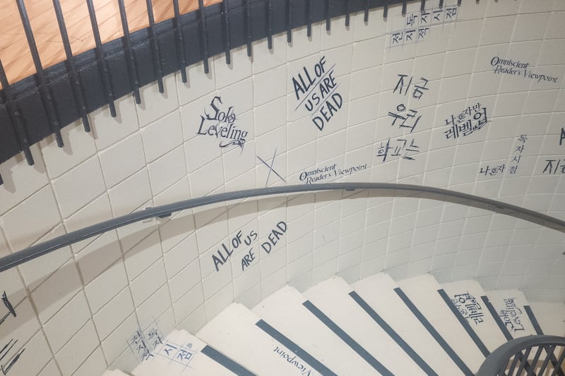 The staircase visitors used to enter the exhibit is decorated with both the Korean and English-translated titles of highlighted webtoons.