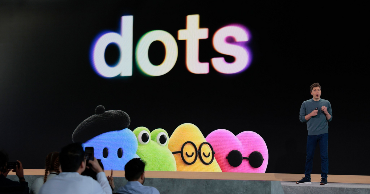 A presenter stands beside a large screen displaying the word "dots" in colorful letters and five colorful cartoon dots with various accessories and expressions.