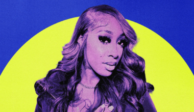 A person with long, wavy hair and bold eyelashes poses with one hand on their chest against a background of bright blue and yellow circles.