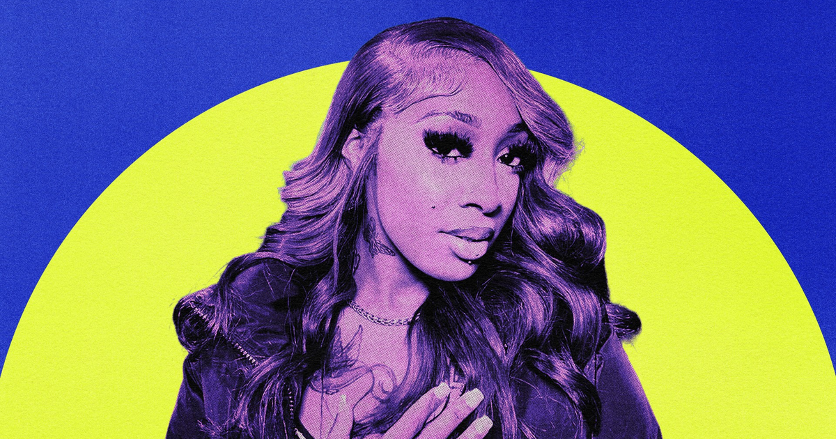 A person with long, wavy hair and bold eyelashes poses with one hand on their chest against a background of bright blue and yellow circles.