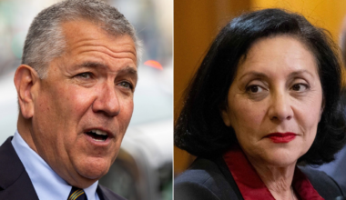 A gray-haired man in a suit talks outdoors, while a black-haired woman with red lipstick and a red blouse looks thoughtfully indoors.