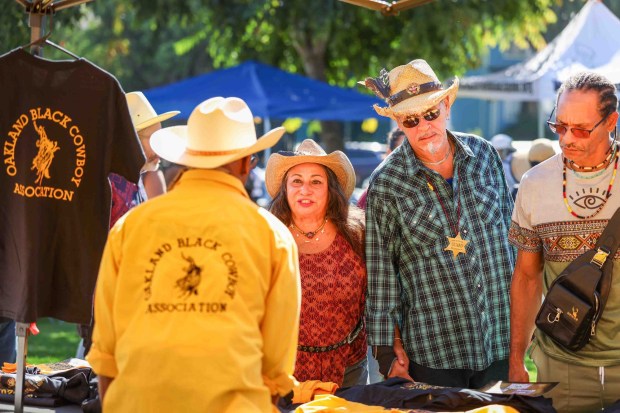 Festivalgoers check out a vendor's booth during the Oakland Black Cowboy Association's 52nd Annual Parade and Festival at DeFremery Park in Oakland, Calif., on Saturday, Oct. 3, 2026. The event brought the community together under the theme "Preserving Our Heritage, Inspiring Our Future," featuring live entertainment, line dancing, youth activities, pony rides, food, local vendors and community resources. (Ray Chavez/Bay Area News Group)