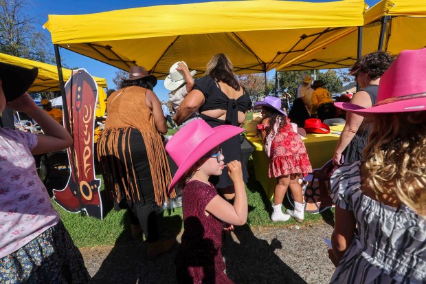 Festivalgoers buy cowboy hats from a vendor's booth during the Oakland Black Cowboy Association's 52nd Annual Parade and Festival at DeFremery Park in Oakland, Calif., on Saturday, Oct. 3, 2026. The event brought the community together under the theme "Preserving Our Heritage, Inspiring Our Future," featuring live entertainment, line dancing, youth activities, pony rides, food, local vendors and community resources. (Ray Chavez/Bay Area News Group)