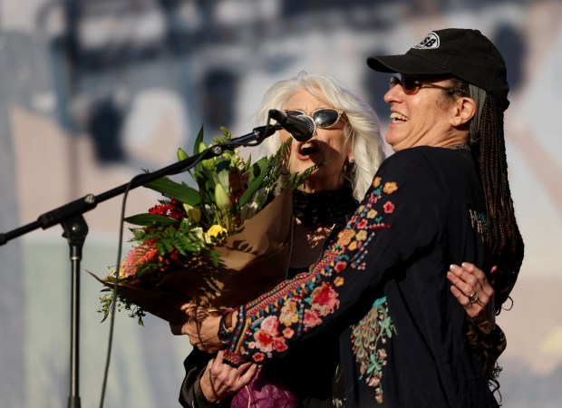 Frances Hellman, right, presents Emmylou Harris with a bouquet of flowers before she performs on the Banjo Stage at the Hardly Strictly Bluegrass Festival in Golden Gate Park in San Francisco, Calif., on Sunday, Oct. 4, 2026. Her dad Warren Hellman founded the free annual HSB festival in 2001. (Jane Tyska/Bay Area News Group)