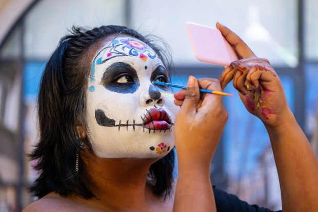 Athena Marbury, of San Francisco, carefully paints her face during the 30th annual Dia de los Muertos Festival in Oakland, Calif., on Sunday, Nov. 2, 2025. (Jose Carlos Fajardo/Bay Area News Group)
