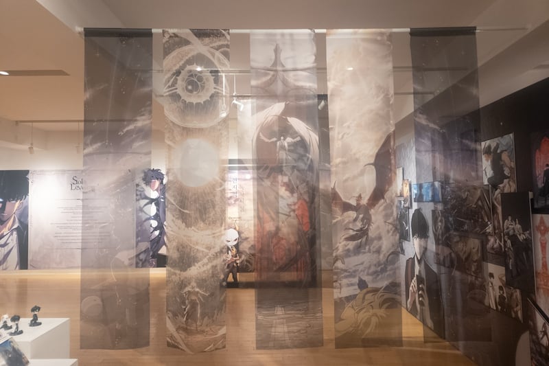 Banners commemorating highlight moments from the webtoon hang from the ceiling.