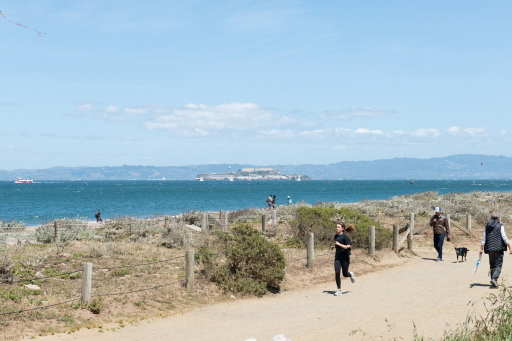 Person runs on a path with Alcatraz in the background