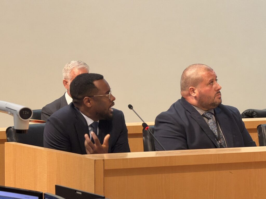 A man speaks at a dais.