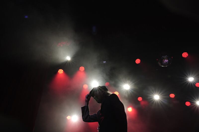 Artist onstage with lights beaming down